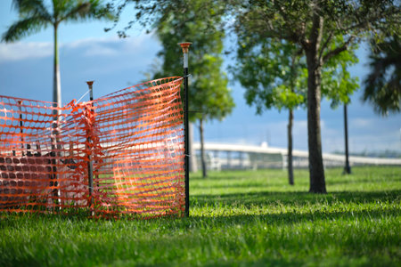 Protective restriction barrier at industrial construction site. Safety mesh fence for pedestrians