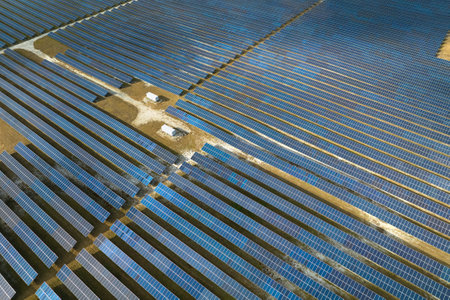 Aerial view of big sustainable electric power plant with many rows of solar photovoltaic panels for...