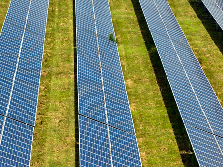 Aerial view of large sustainable electrical power plant with rows of solar photovoltaic panels for...