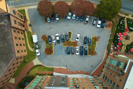 Aerial view of many colorful cars parked on parking lot on apartment building backyard. Place for vehicles in front of residential condoの写真素材