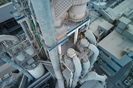 Cement plant with high factory structure and tower cranes at industrial production area. Manufacture and global industry conceptの写真素材