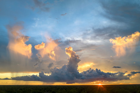 Cumulonimbus clouds forming before thunderstorm on evening sky. Changing stormy cloudscape weather at sunsetの写真素材