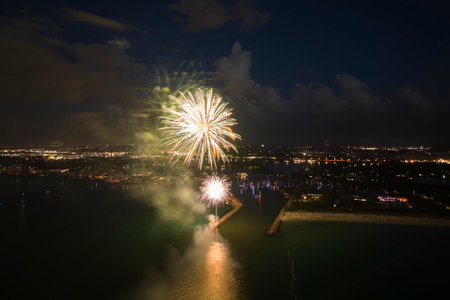 Aerial view of bright fireworks exploding with colorful lights over sea shore on US Independence day holidayの写真素材