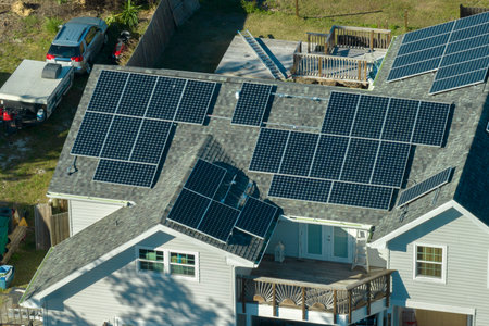 Residential house in USA with rooftop covered with solar photovoltaic panels for producing of clean...