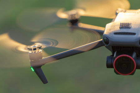 Drone quadcopter with digital camera and fast rotating propellers flying taking video and picturesの写真素材