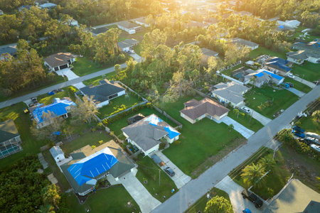 Top view of leaking house roofs covered with protective tarp sheets against rain water leaks until...