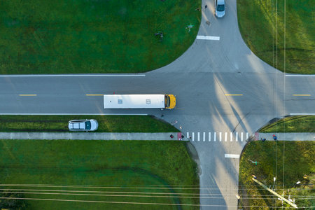 Aerial view of american yellow school bus picking up children at sidewalk bus stop for their lessongs in early morning. Public transportation in the USAの写真素材