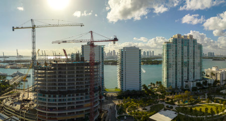 New construction site of developing residense in american urban area. Industrial tower lifting cranes in Miami, Florida. Concept of housing growth in the USAの写真素材