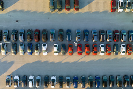 Large parking lot of local dealer with many brand new cars parked for sale. Development of american automotive industry and distribution of manufactured vehicles conceptの写真素材