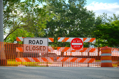 Yellow protective fence barrier at street construction site. Warning road sign about utility workの写真素材