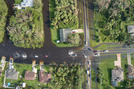 Aerial view of flooded street after hurricane rainfall with driving cars in Florida residential area. Consequences of natural disasterの写真素材