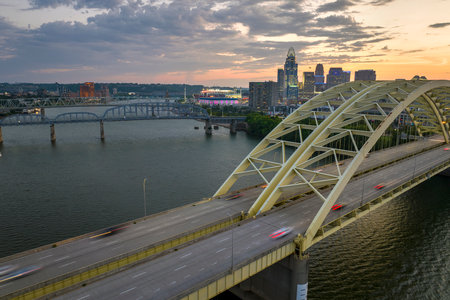 Night urban landscape of downtown district of Cincinnati city in Ohio, USA. Skyline with driving cars on bridge and brightly illuminated high skyscraper buildings in modern American megapolisの写真素材