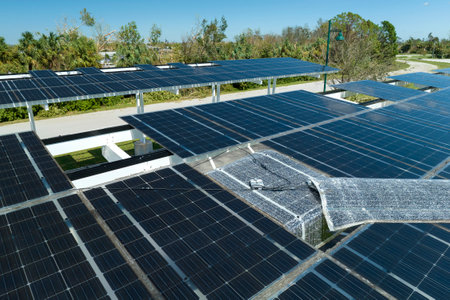 Wind damage to solar panels installed over parking lot canopy shade for parked cars for effective generation of clean energyの写真素材