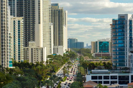 Aerial view of Sunny Isles Beach city with congested street traffic and luxurious highrise hotels and condos on Atlantic ocean shore. American tourism infrastructure in southern Floridaの写真素材