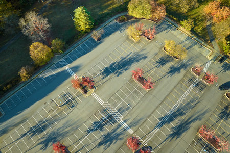Aerial view of large parking lot with many parked colorful cars. Carpark at supercenter shopping mall with lines and markings for vehicle places and directionsの写真素材