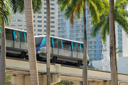 City train car on high railroad over street traffic between skyscraper buildings in modern American...