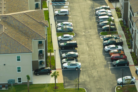 Cars parked on parking place of new apartment condos in Florida suburban area. Family housing in quiet neighborhood. Real estate development in american suburbsの写真素材