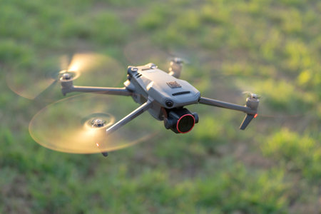 Drone quadcopter with digital camera and fast rotating propellers flying taking video and picturesの写真素材