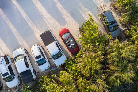 Parking lot at Blind Pass beach on Manasota Key in Englewood. Tourists cars in front of ocean beach with soft white sand in Florida. Popular vacation spot at sunsetの写真素材