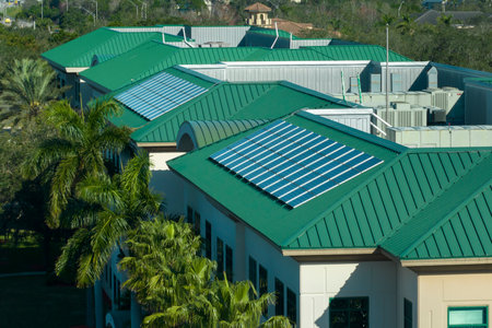 Residential apartment building with rooftop covered with solar photovoltaic panels for producing of clean ecological electrical energy. Concept of autonomous housingの写真素材
