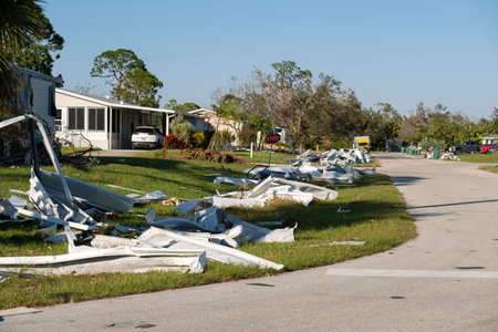 Scrap metal disposed in heaps on street side after hurricane severely damaged houses in Florida mobile home residential area. Consequences of natural disasterの写真素材