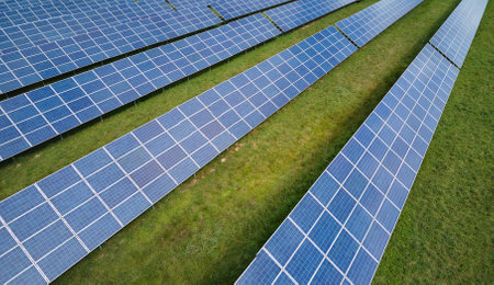 Aerial view of large sustainable electrical power plant with rows of solar photovoltaic panels for...