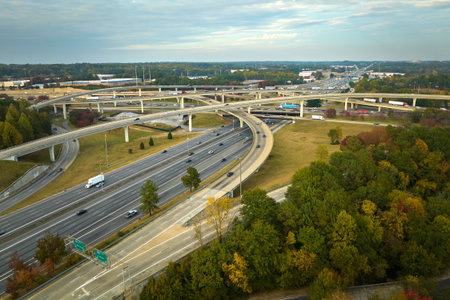 Aerial view of american freeway intersection with fast moving cars and trucks. USA transportation...