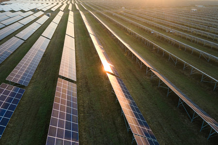 Aerial view of big sustainable electric power plant with many rows of solar photovoltaic panels for...