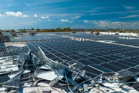 Top view of destroyed by hurricane Ian photovoltaic solar panels mounted on industrial building roof...