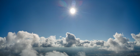 Aerial view from airplane window at high altitude of earth covered with white puffy cumulus clouds