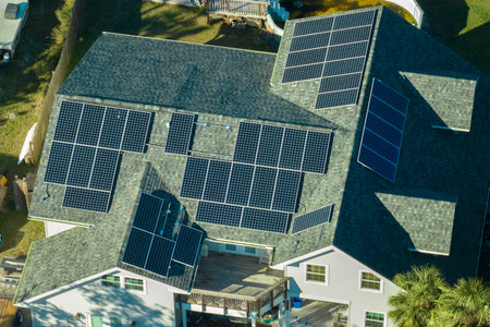 Aerial view of american home roof with blue solar photovoltaic panels for producing clean ecological...