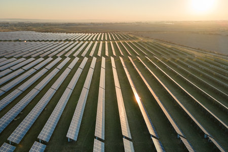 Aerial view of big sustainable electric power plant with many rows of solar photovoltaic panels for...