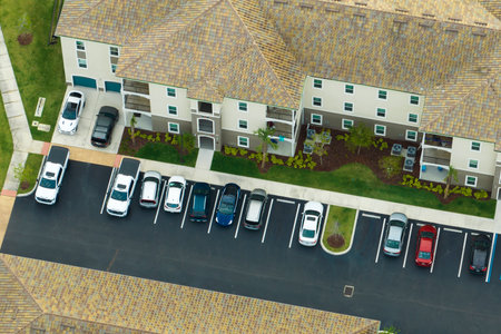 Aerial view of cars parked on parking places at american apartment building in Florida residential area. New family condos as example of housing development in US suburbsの写真素材