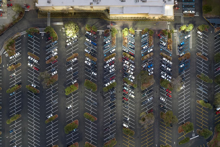 Aerial view of many cars parked on parking lot with lines and markings for parking places and...