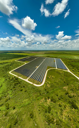 Aerial view of big sustainable electric power plant with many rows of solar photovoltaic panels for...