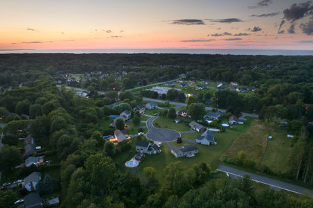 View from above of residential houses in living area in Rochester, NY at sunset. Illuminated...