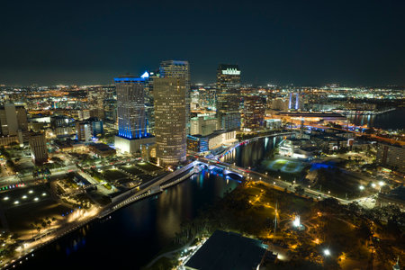 Aerial view of downtown district of Tampa city in Florida, USA. Brightly illuminated high skyscraper buildings, pedestrian riverwalk and moving traffic in modern american midtownの写真素材
