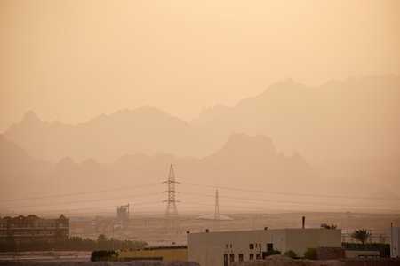 Sunset landscape with remote hotel complex against dark mountain peaks in egyptian desert