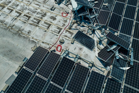 Photovoltaic solar panels destroyed by hurricane strong wind mounted on industrial building roof for...