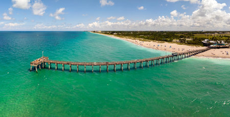 Summer landscape at Venice fishing pier in Florida. Ocean surf waves crashing on warm sandy beachの写真素材