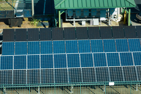 Aerial view of blue solar photovoltaic panels mounted on fenced backyard for producing clean...