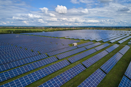 Aerial view of large sustainable electrical power plant with rows of solar photovoltaic panels for...