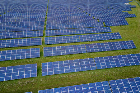 Aerial view of large sustainable electrical power plant with rows of solar photovoltaic panels for...