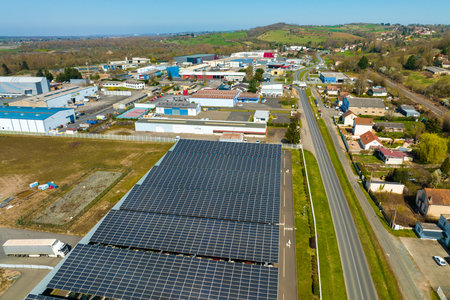 Aerial view of solar panels installed over parking lot with parked cars for effective generation of...