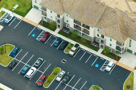 Cars parked on parking place of new apartment condos in Florida suburban area. Family housing in...