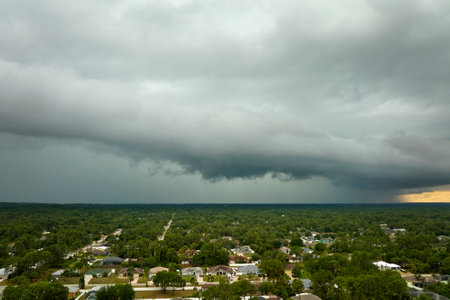 Dark stormy clouds forming on gloomy sky before heavy rainfall over suburban town area