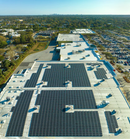 Electric photovoltaic solar panels installed on shopping mall building rooftop for production of...