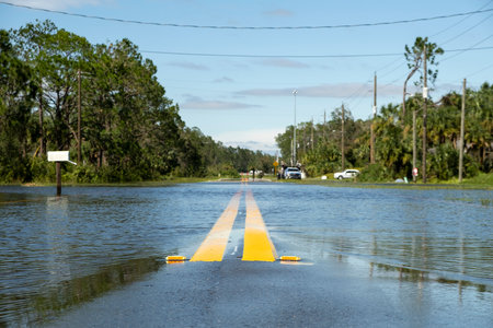 Hurricahe rainfall flooded Florida road in suburban residential area. Driving hazardous conditions