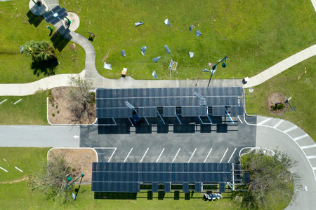 Hurricane wind damage to solar panels installed as shade roof over parking lot for parked electric...