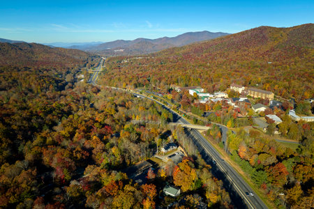 Aerial view of I-40 freeway in North Carolina leading to Asheville through Appalachian mountains in golden fall with fast moving trucks and cars. Interstate transportation conceptの写真素材
